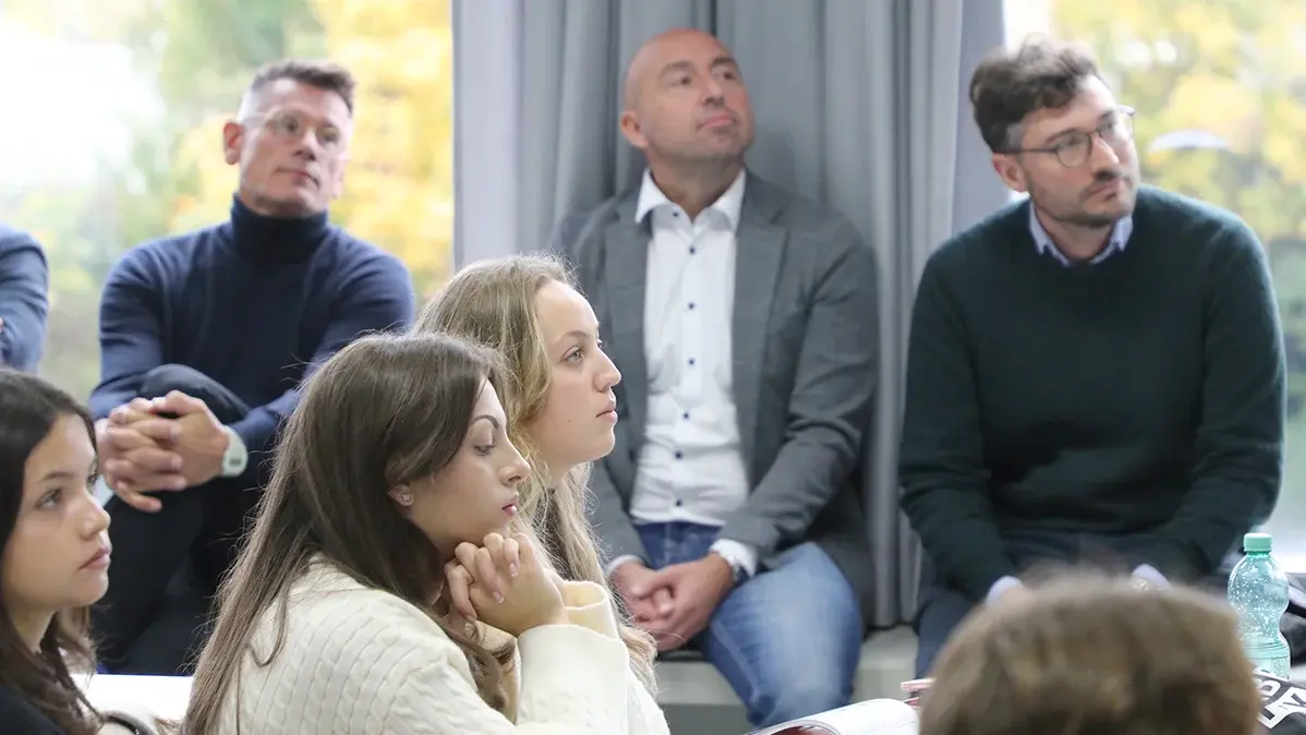 Eine kleine Gruppe Studierender und Lehrende sitzen zusammen.