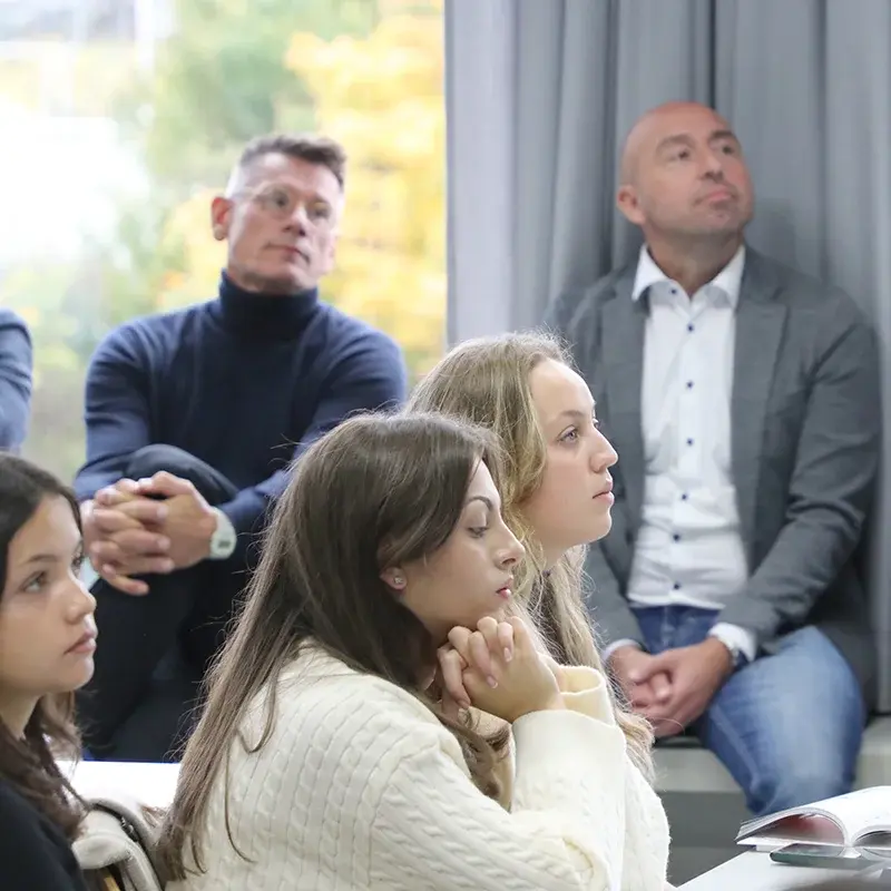 Eine kleine Gruppe Studierender und Lehrende sitzen zusammen.