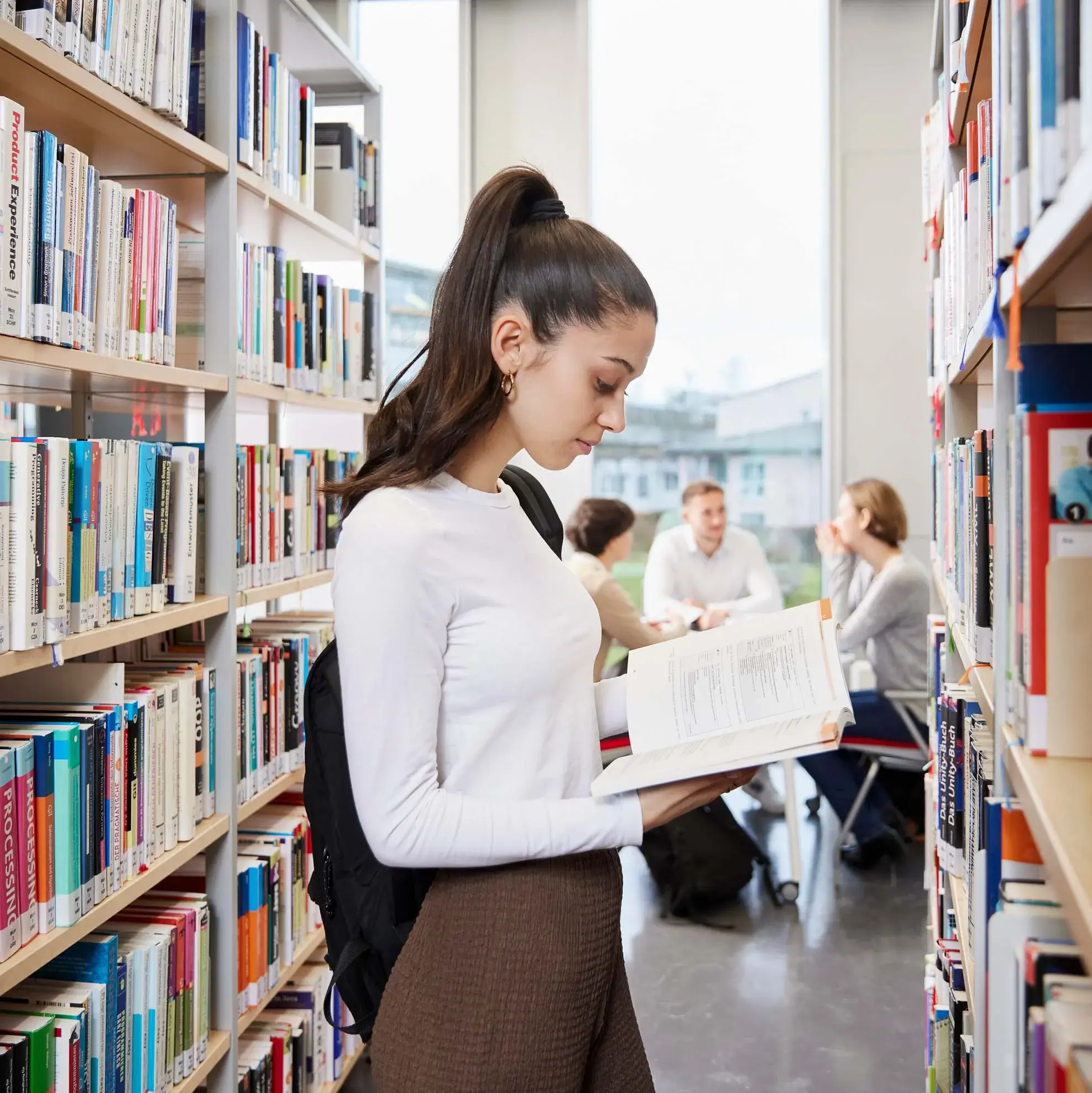 Eine Studierende liest ein Buch in der Bibliothek der Hochschule der Medien.