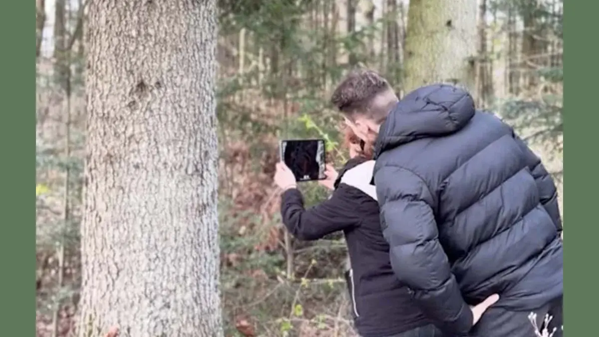 Zwei Studierende im Wald verwenden die VR-Brille, um die VR-App Waldlupe erlebbar zu machen.