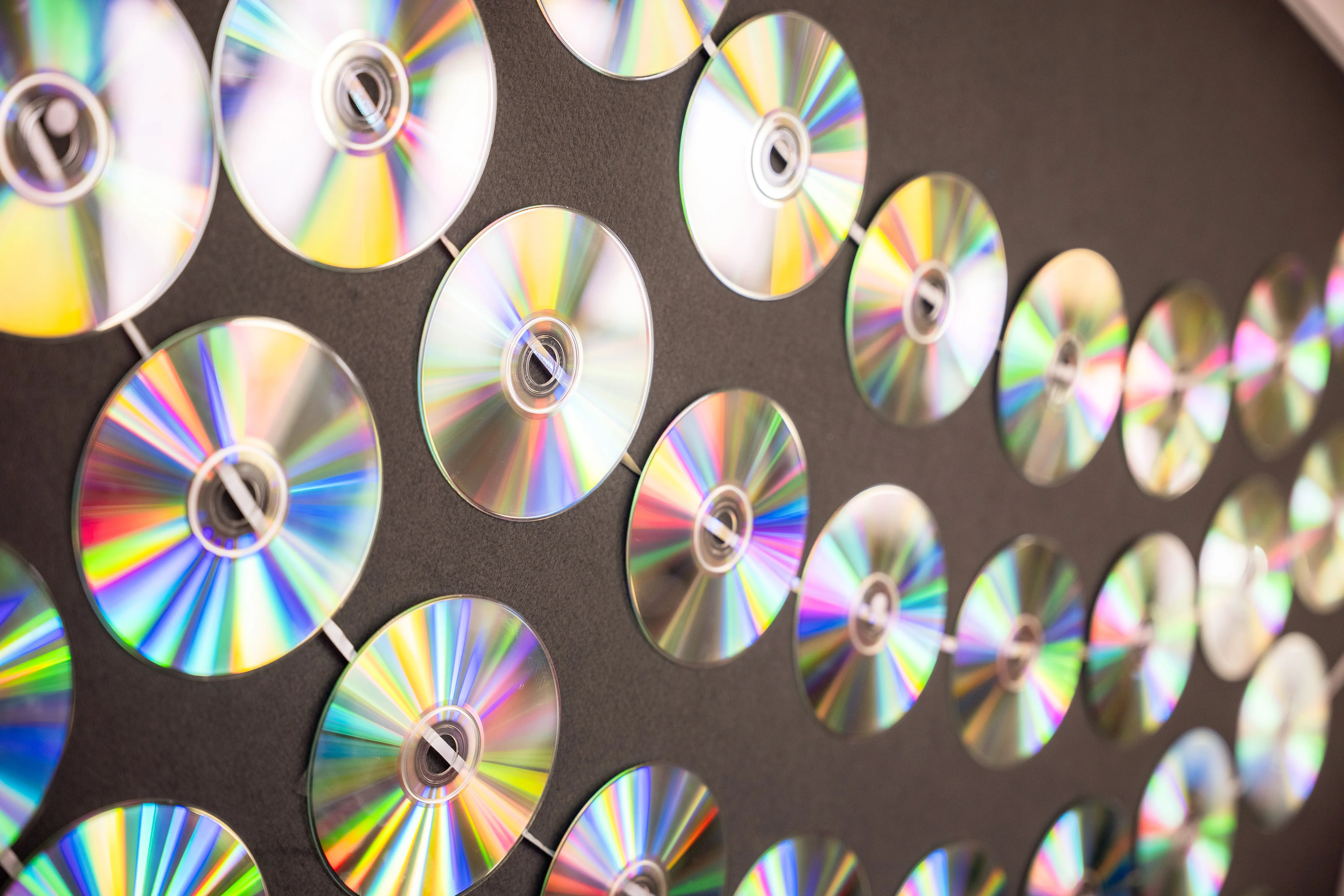 Schillernde CD-Rohlinge sind zur Dekoration an der Wand befestigt.