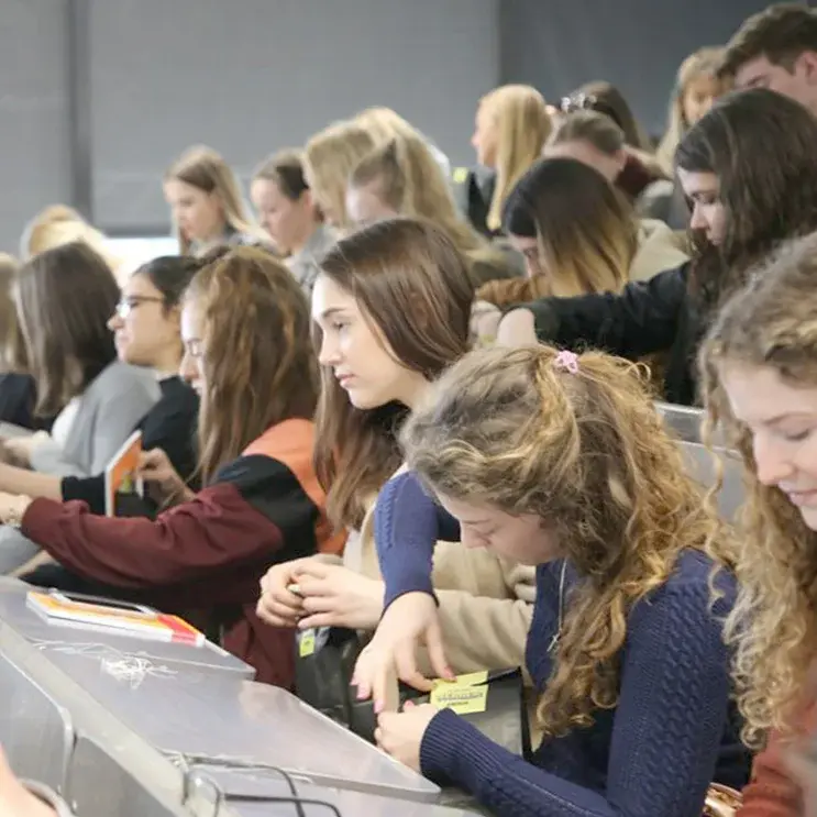 Die Erstsemesterstudierenden werden in einem Stufenhörsaal sitzend vom Studiengang WM begrüßt.