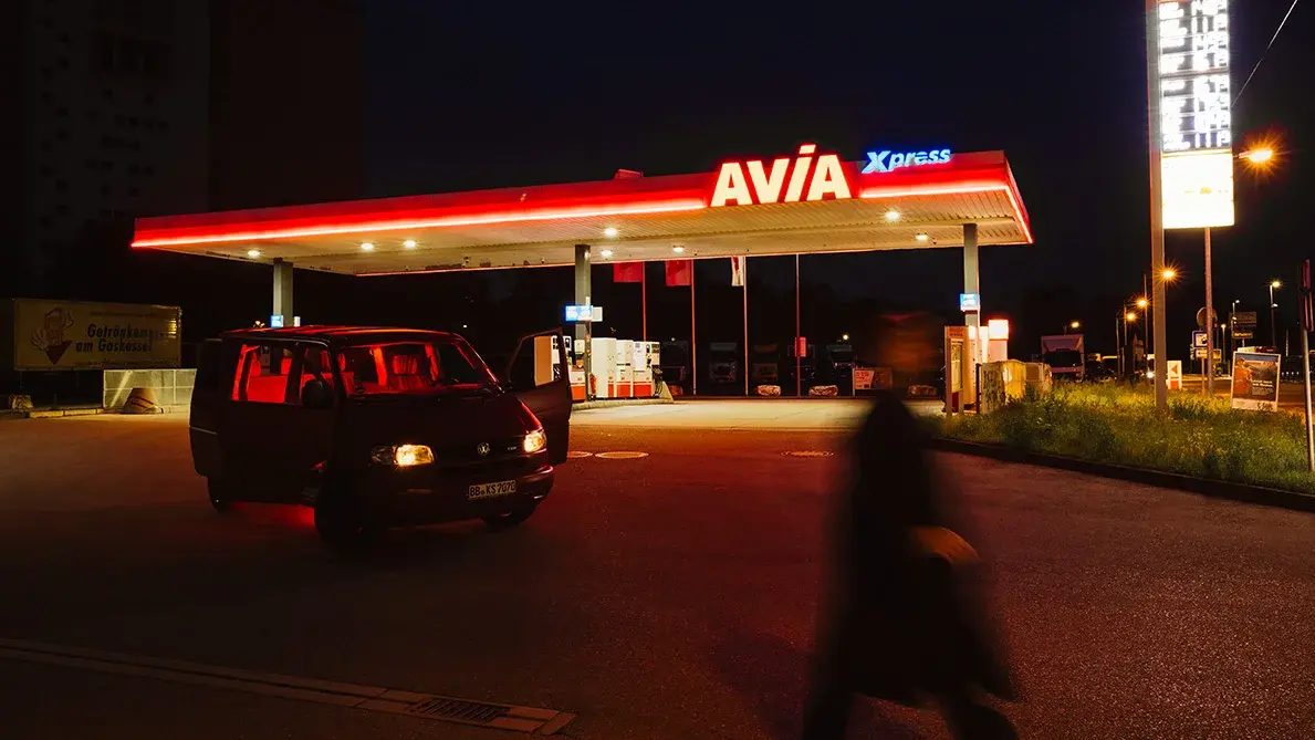 Eine Tankstelle in der Ferne bei Nacht.