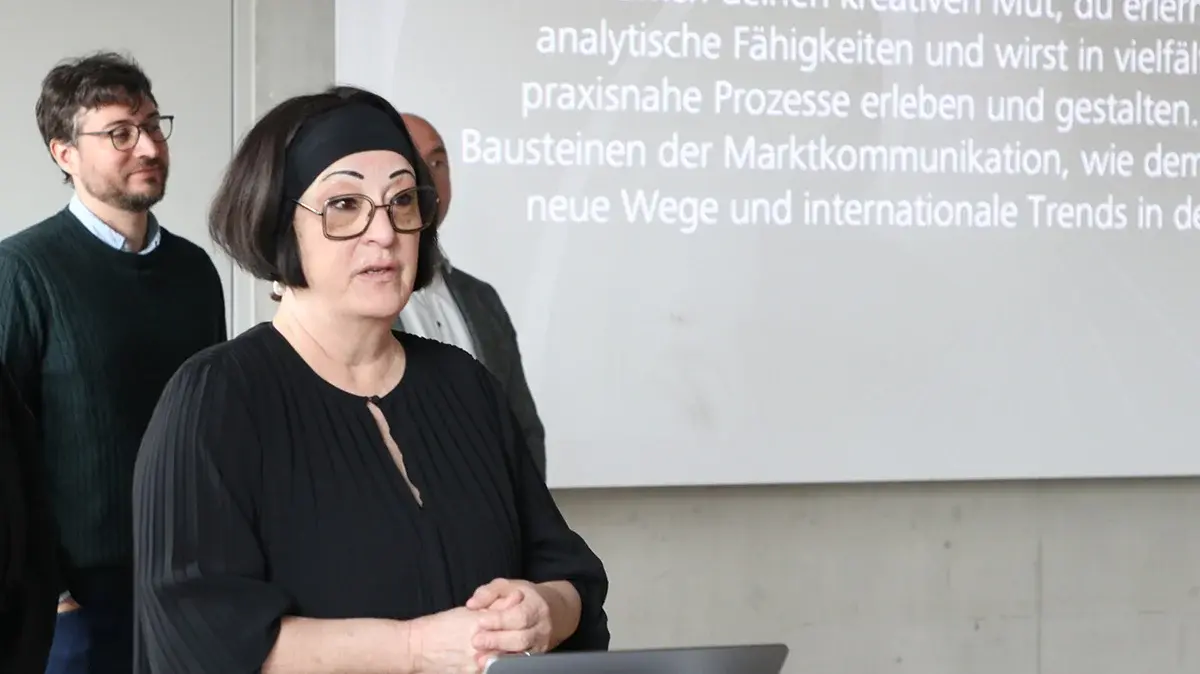 Eine Professorin begrüßt die Anwesenden