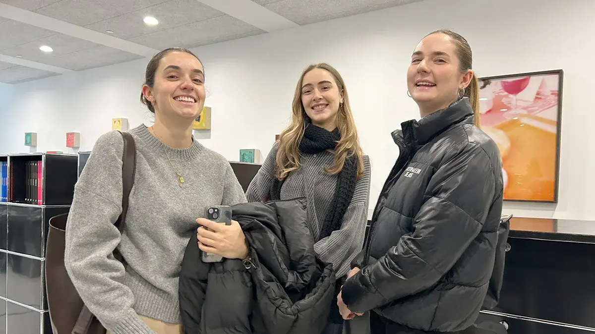 Drei Studentinnen stehen in der Agentur LMWA.