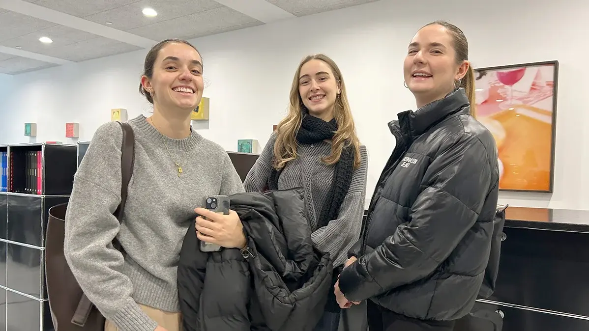 Drei Studentinnen stehen in der Agentur LMWA.