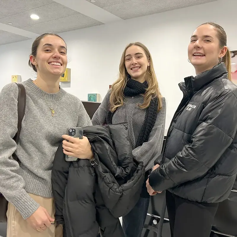 Drei Studentinnen stehen in der Agentur LMWA.